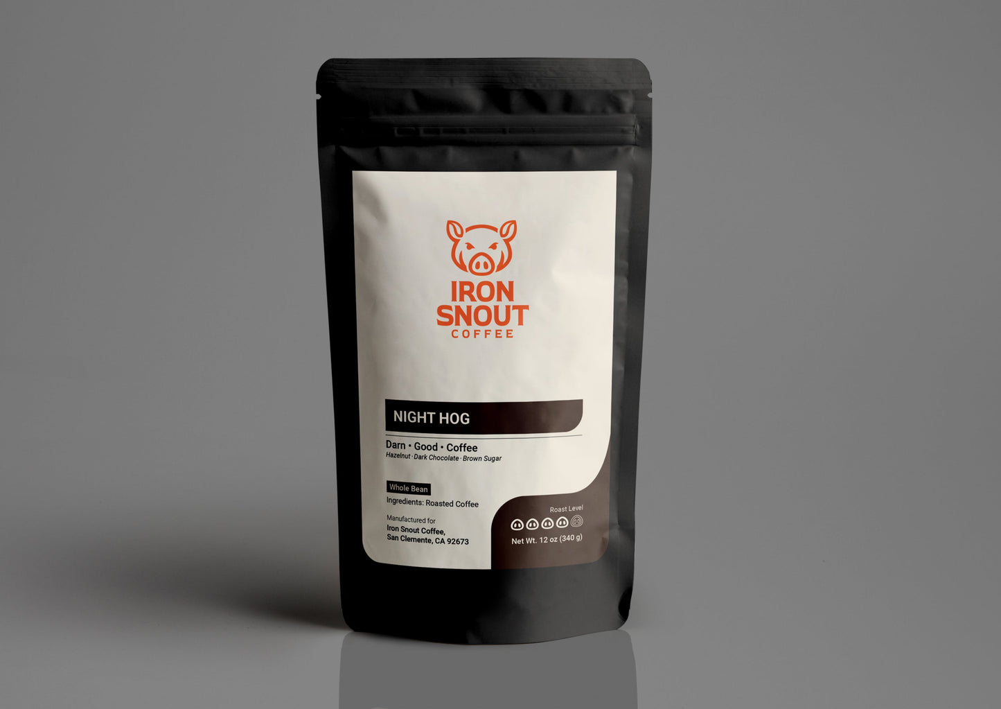 The black coffee bag, labeled "Iron Snout Coffee Night Hog" with a pig logo, is placed on a gray surface.